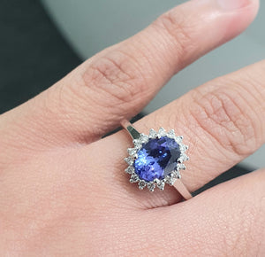 1.70ct Oval Cut Tanzanite Centre | 0.20cts [18] Round Brilliant Cut Diamonds | Halo Design Ring | 9kt White Gold